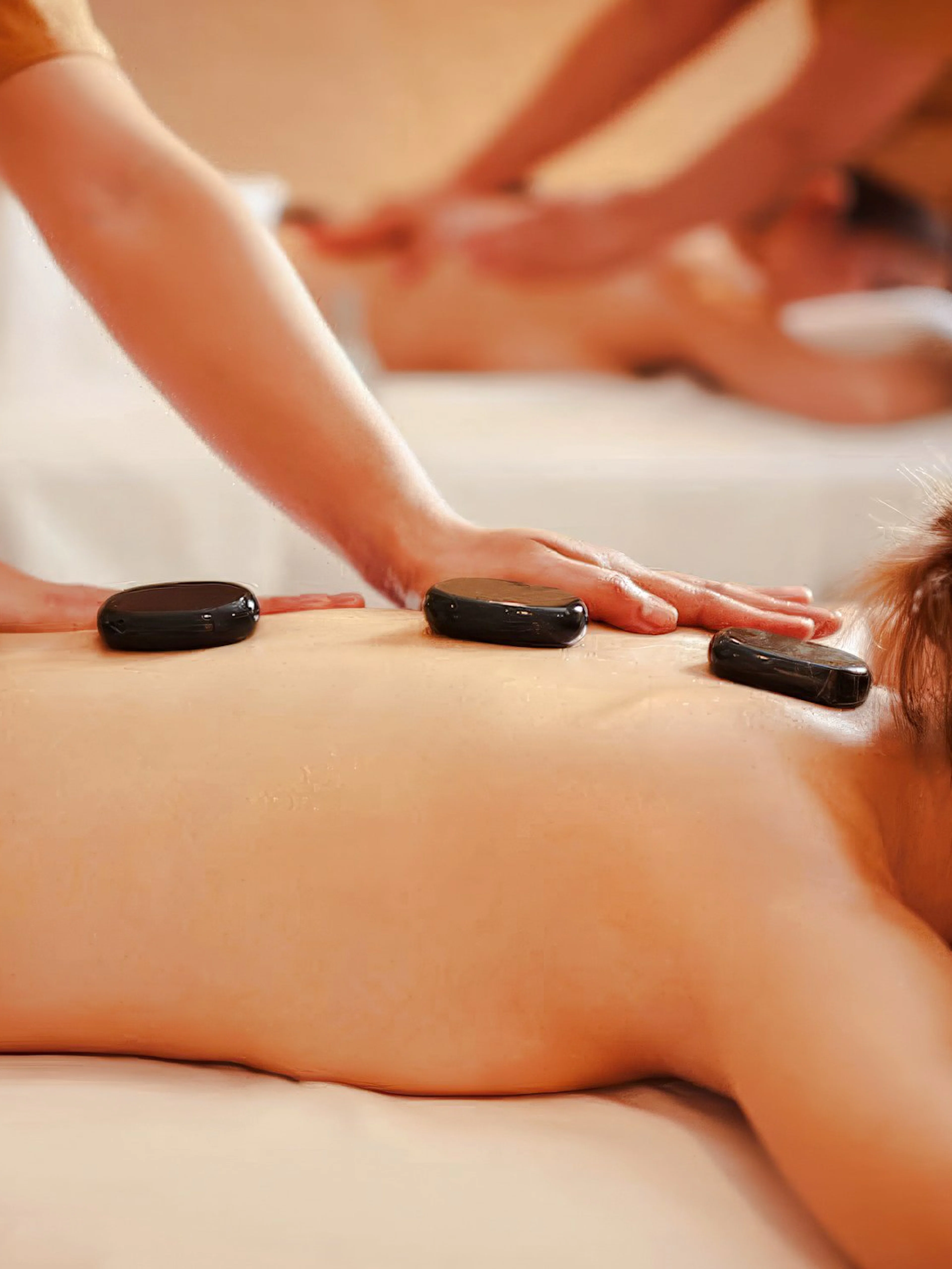 Hot stone massage with organic aromatherapy oils on a spa table.