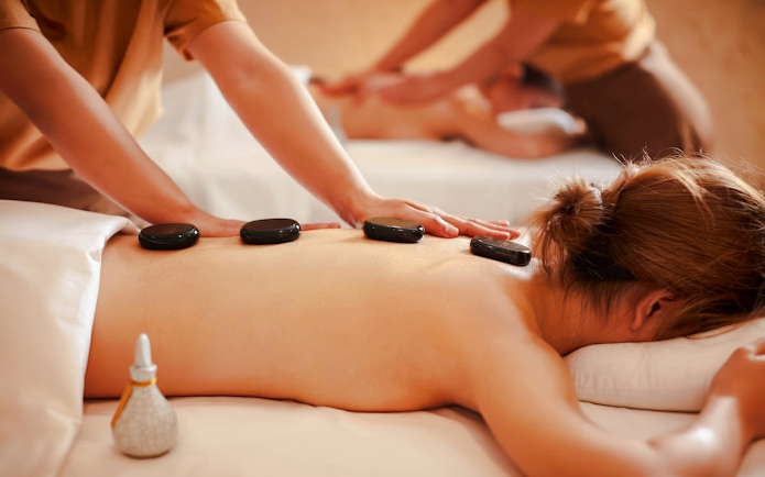 Hot stone massage with organic aromatherapy oils on a spa table.