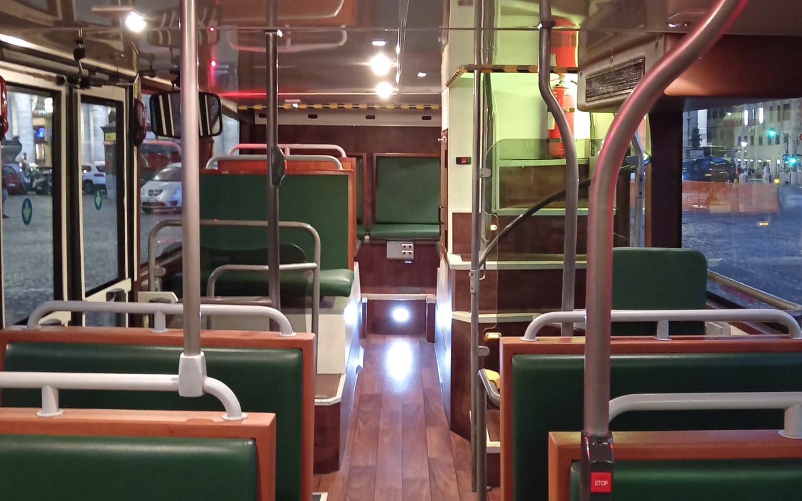Vintage bus interior with green seats and wooden accents.