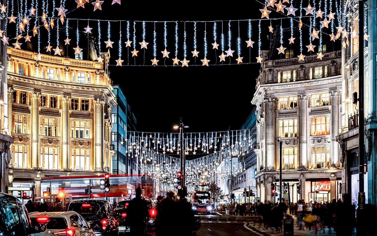 London street with Christmas lights and double-decker bus during Big Bus: London Christmas Lights Night Bus Tour.