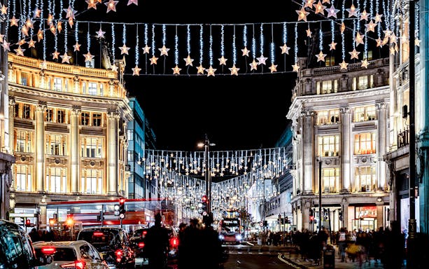 London street with Christmas lights and double-decker bus during Big Bus: London Christmas Lights Night Bus Tour.