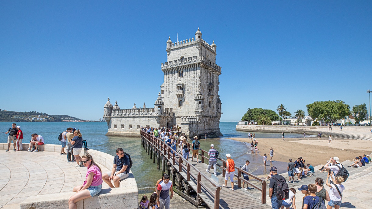 Visitors walking on a bridge to Belém Tower in Lisbon, Portugal.