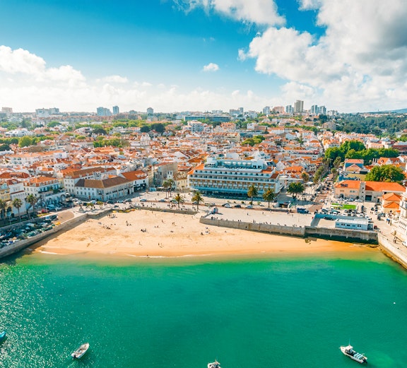 Aerial view of Cascais bay with sandy beach and town buildings, Portugal.