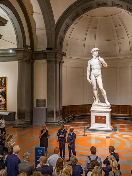 Visitors on a guided tour viewing Michelangelo's David at Accademia Gallery, Florence.