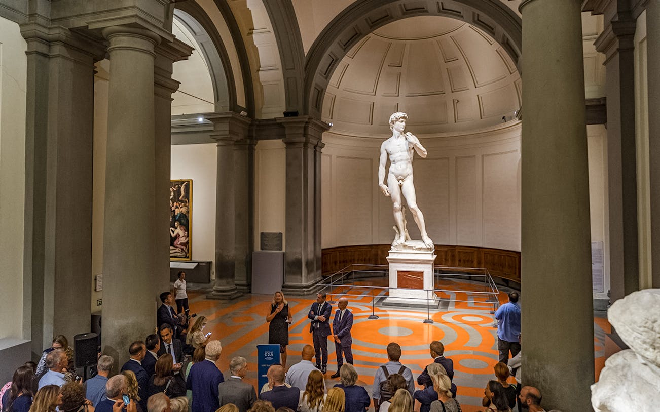 Visitors on a guided tour viewing Michelangelo's David at Accademia Gallery, Florence.