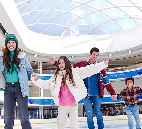 People ice skating at the American Dream ice rink under a glass dome.