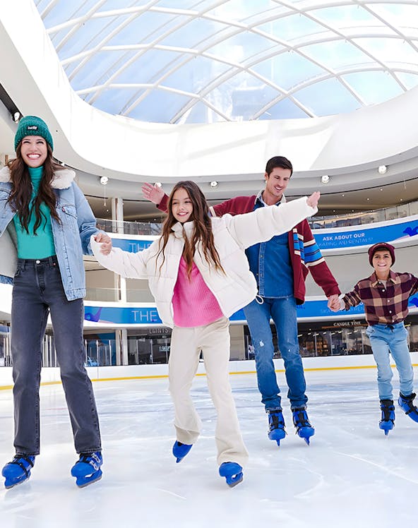 People ice skating at the American Dream ice rink under a glass dome.