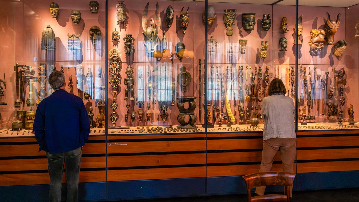 Visitors viewing African masks and artifacts at the Land Unknown exhibit, National Museum of Denmark.