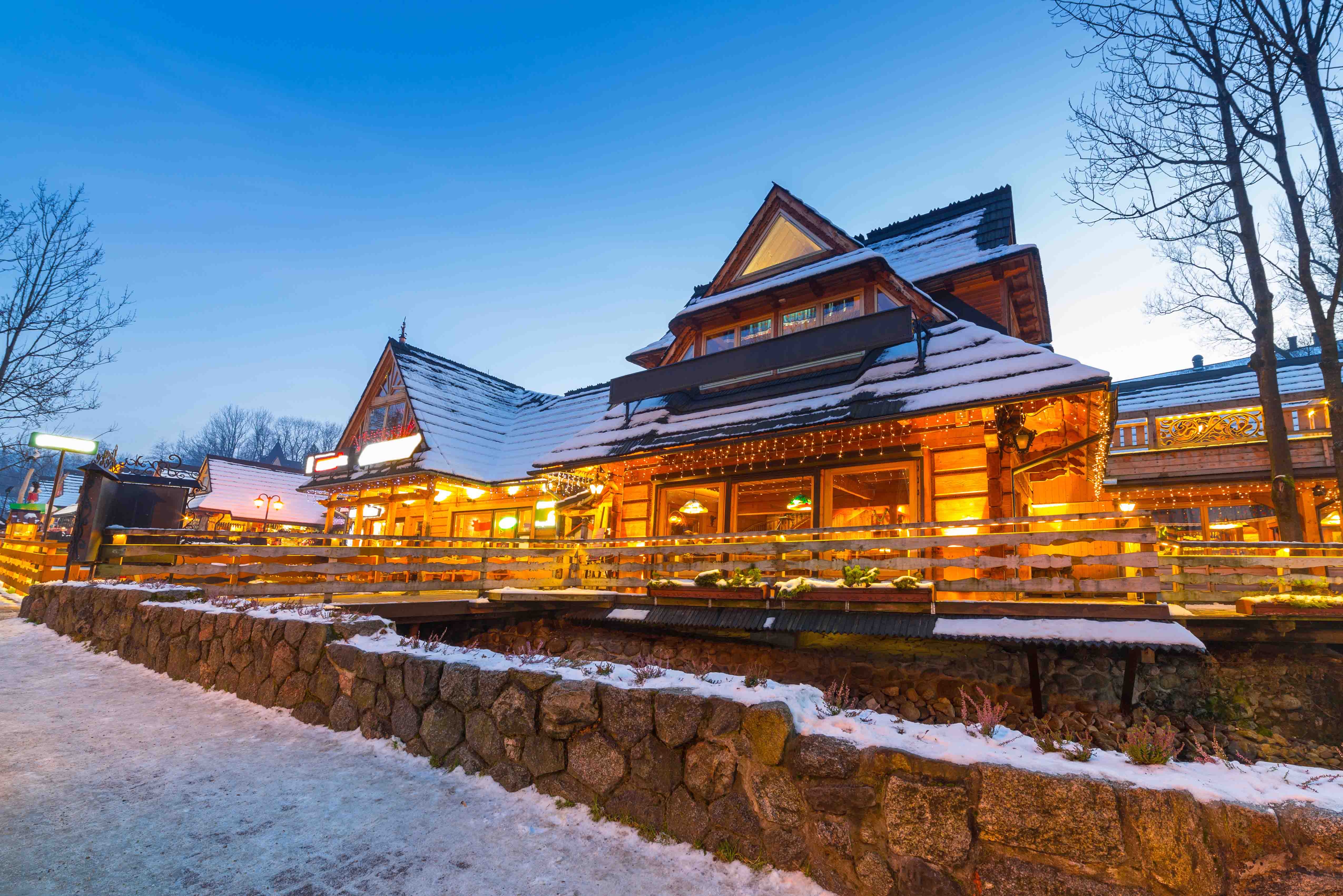 Krupowki street in Zakopane with traditional wooden buildings at dusk.
