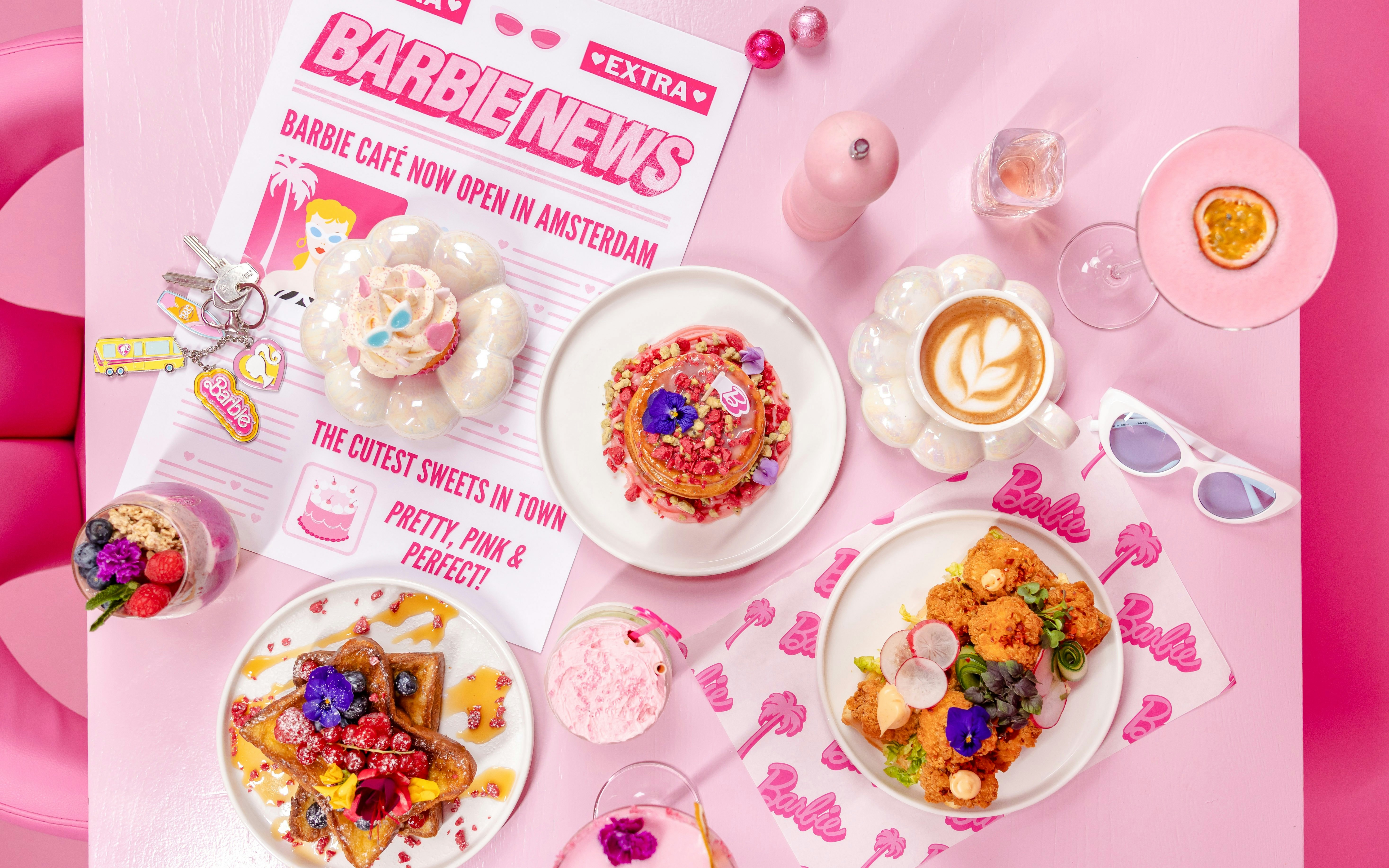 Barbie-themed cafe table with colorful desserts and drinks in Amsterdam.