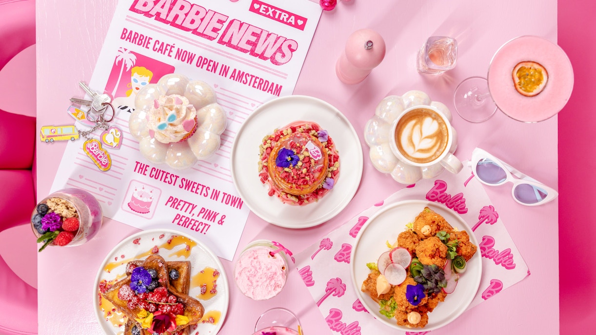 Barbie-themed cafe table with colorful desserts and drinks in Amsterdam.