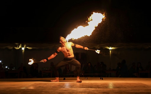 Fire performer breathing flames during a Classic Overnight Desert Safari.