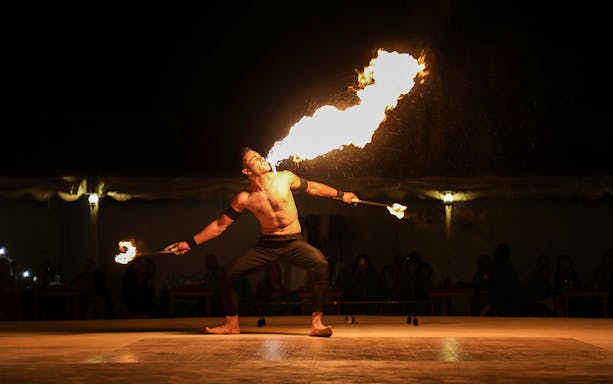 Fire performer breathing flames during a Classic Overnight Desert Safari.