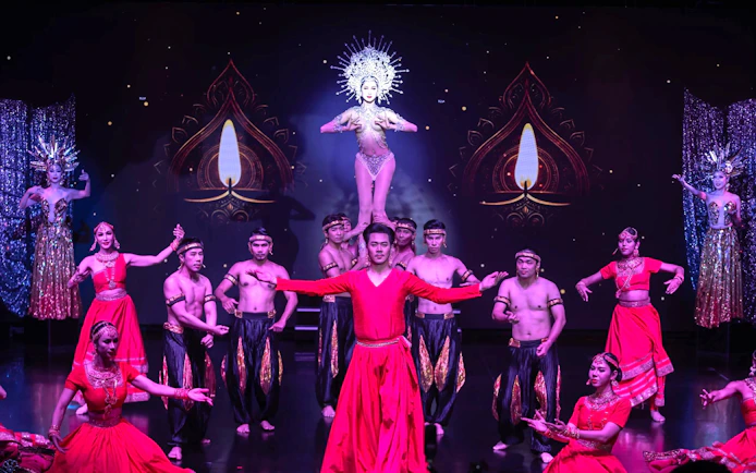 Performers in traditional costumes during Calypso Cabaret show in Bangkok.
