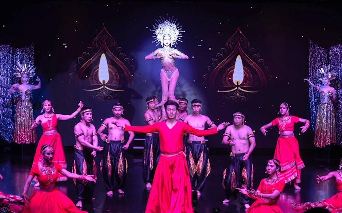 Performers in traditional costumes during Calypso Cabaret show in Bangkok.