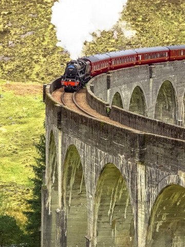 Steam train crossing the Glenfinnan Viaduct in Isle of Skye, Scotland.