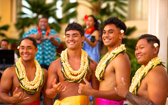 Men in traditional Hawaiian attire with leis at Na Lei Aloha Luau, Waikīkī.