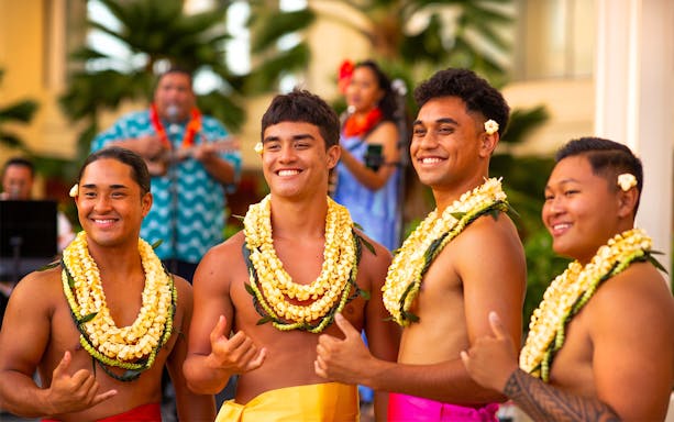 Men in traditional Hawaiian attire with leis at Na Lei Aloha Luau, Waikīkī.