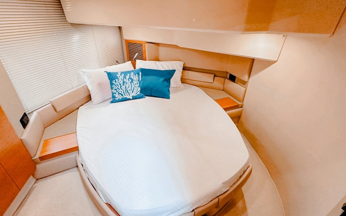 Private yacht bedroom with round bed and blue coral pillow, Dubai.