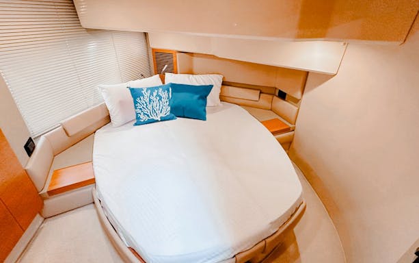 Private yacht bedroom with round bed and blue coral pillow, Dubai.