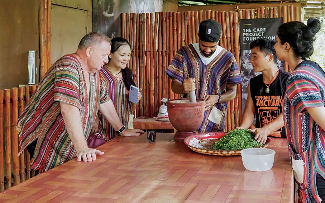 Group preparing a meal with mortar and pestle at the sanctuary.
