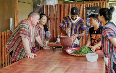 Group preparing a meal with mortar and pestle at the sanctuary.