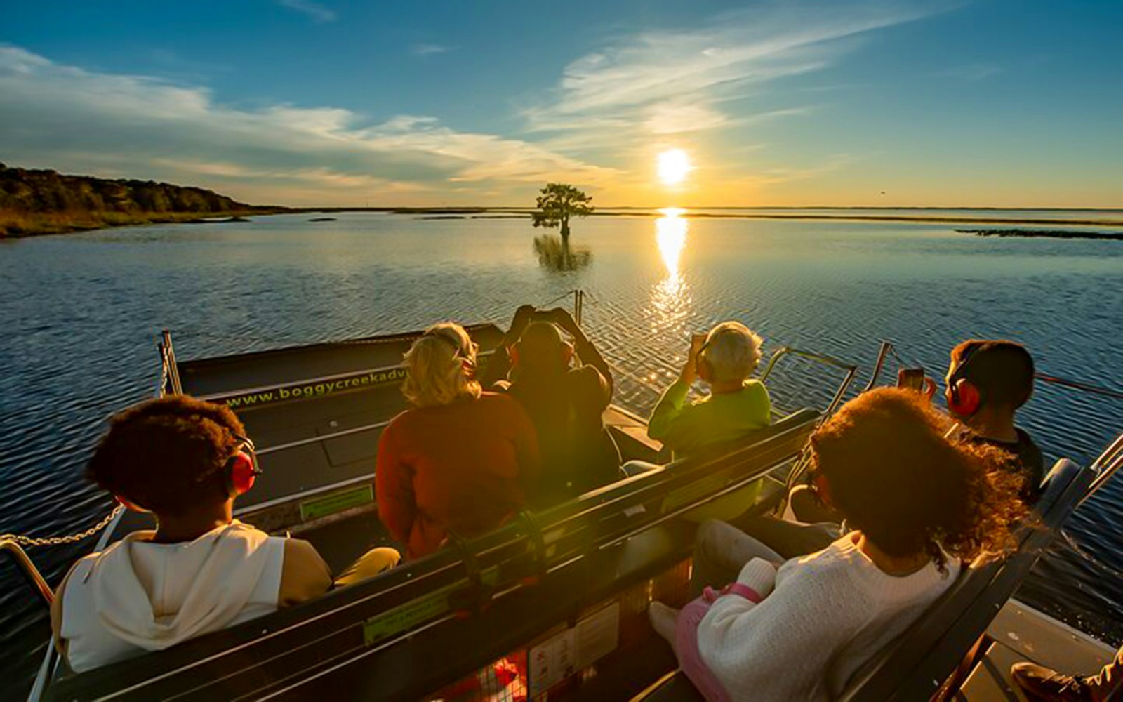 Guests on an airboat ride at sunset during Boggy Creek 1 Hour Sunset Airboat Tour.