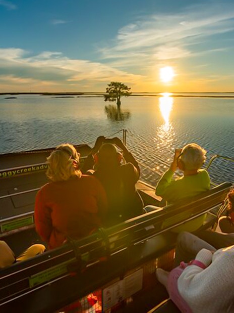 Guests on an airboat ride at sunset during Boggy Creek 1 Hour Sunset Airboat Tour.