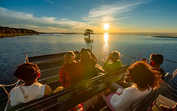 Guests on an airboat ride at sunset during Boggy Creek 1 Hour Sunset Airboat Tour.