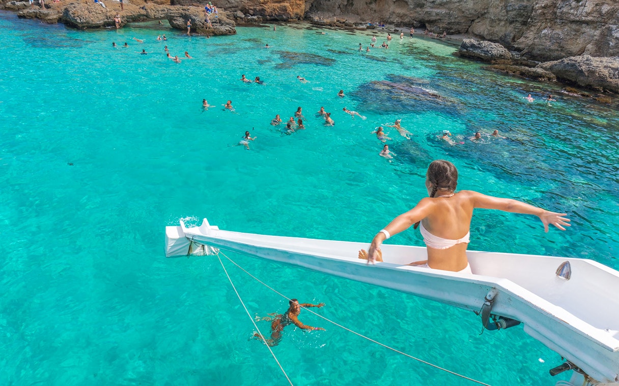 Girl sliding off cruise ship into Blue Lagoon, Malta.