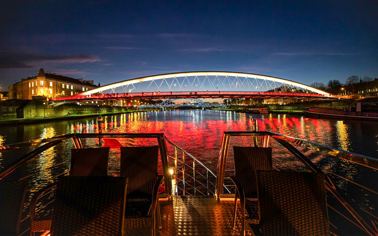 Vistula River night cruise view of Warsaw skyline from catamaran.