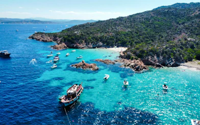 Motorboats exploring the turquoise waters of La Maddalena Archipelago, Italy.