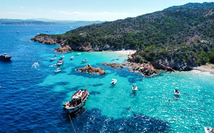 Motorboats exploring the turquoise waters of La Maddalena Archipelago, Italy.