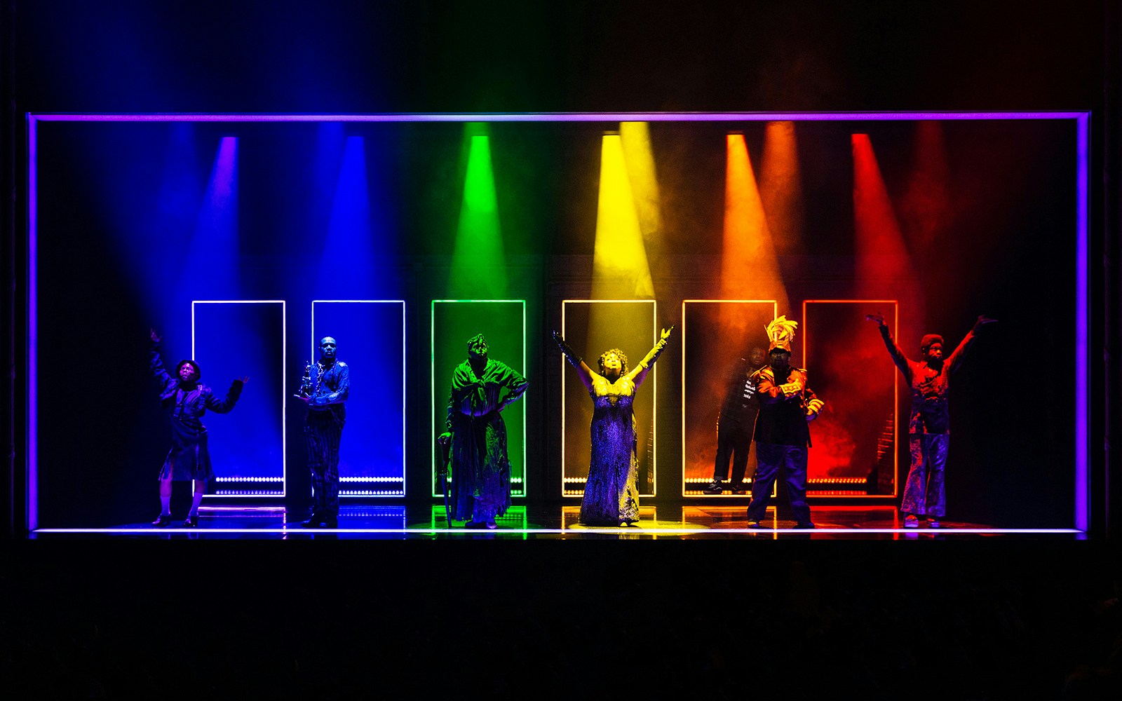 Performers on stage in colorful lighting for "A Strange Loop" musical.