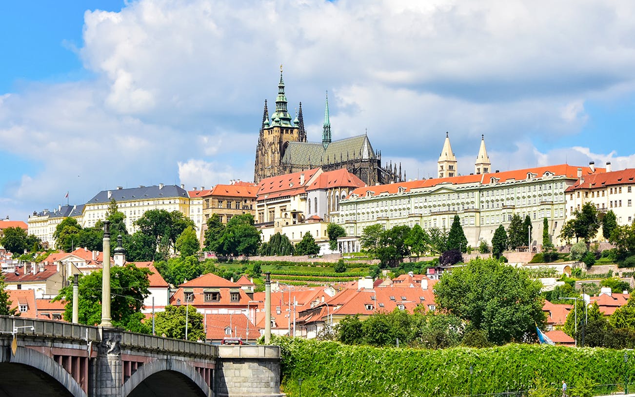 Prague Castle exterior with Gothic spires and surrounding historic buildings.
