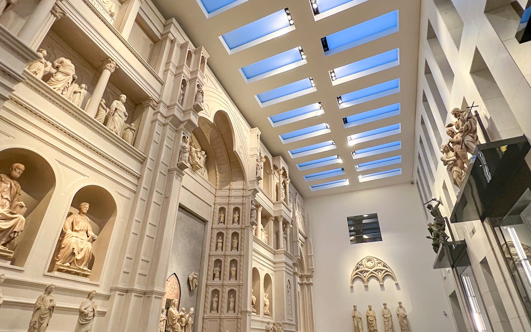 Interior view of Florence Duomo Museum with sculptures and architectural details.