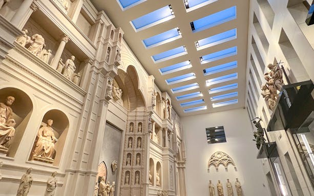Interior view of Florence Duomo Museum with sculptures and architectural details.