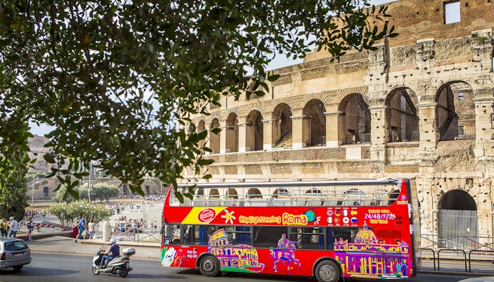 Open-top tour bus in front of the Colosseum, Rome.