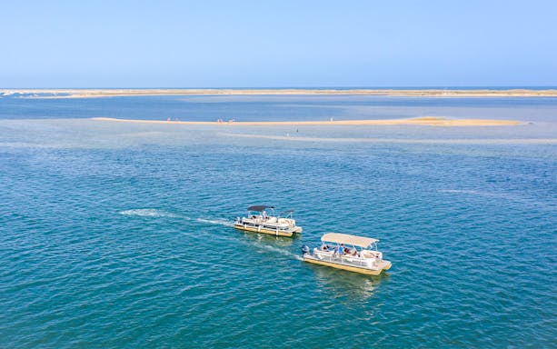 Boat tour approaching Deserta and Farol Islands in Ria Formosa, Portugal.