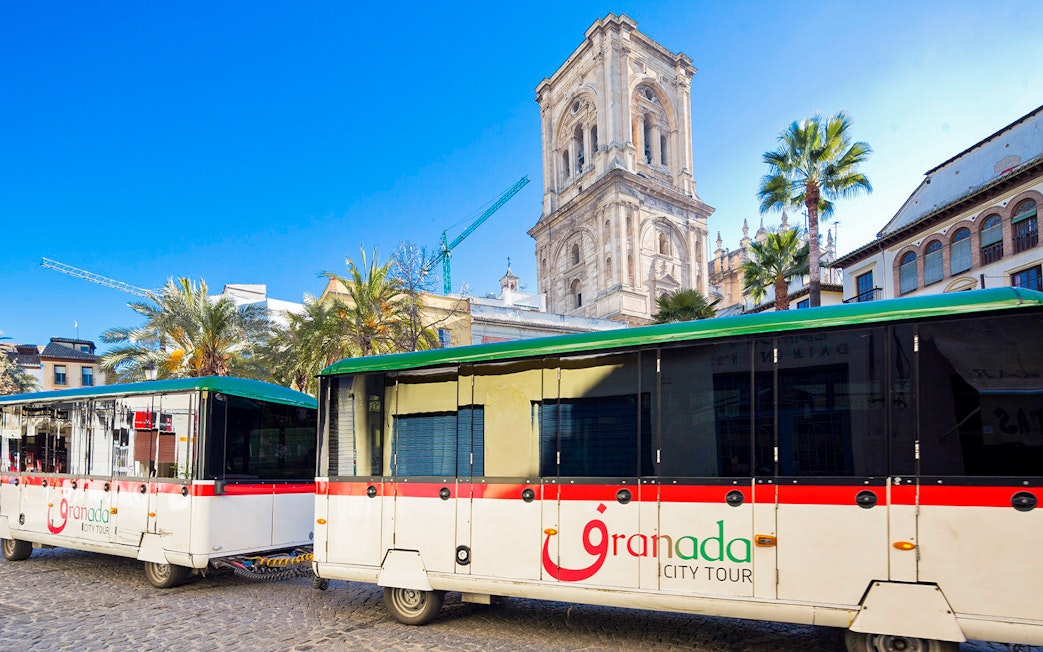 Granada city tour buses in front of historic cathedral.