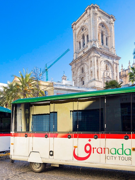 Granada city tour buses in front of historic cathedral.