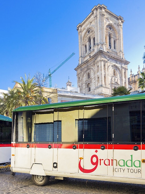 Granada city tour buses in front of historic cathedral.