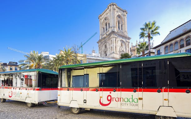 Granada city tour buses in front of historic cathedral.
