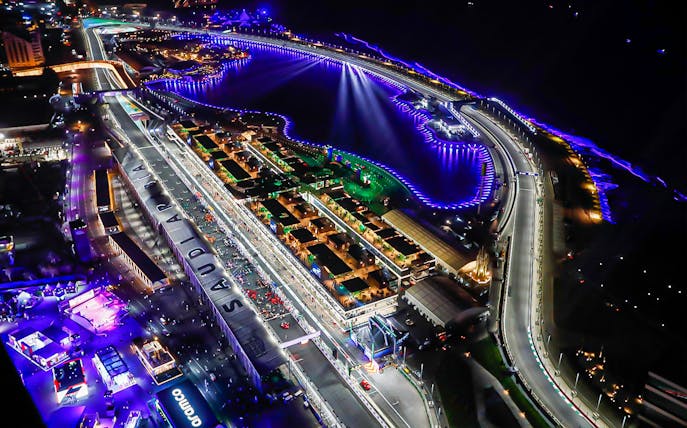 Aerial view of Saudi Arabia F1 Grand Prix circuit illuminated at night, showcasing the track and surrounding area.