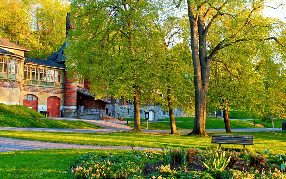 Historic building and lush park in Stockholm, part of the Royal Vikings city exploration game.
