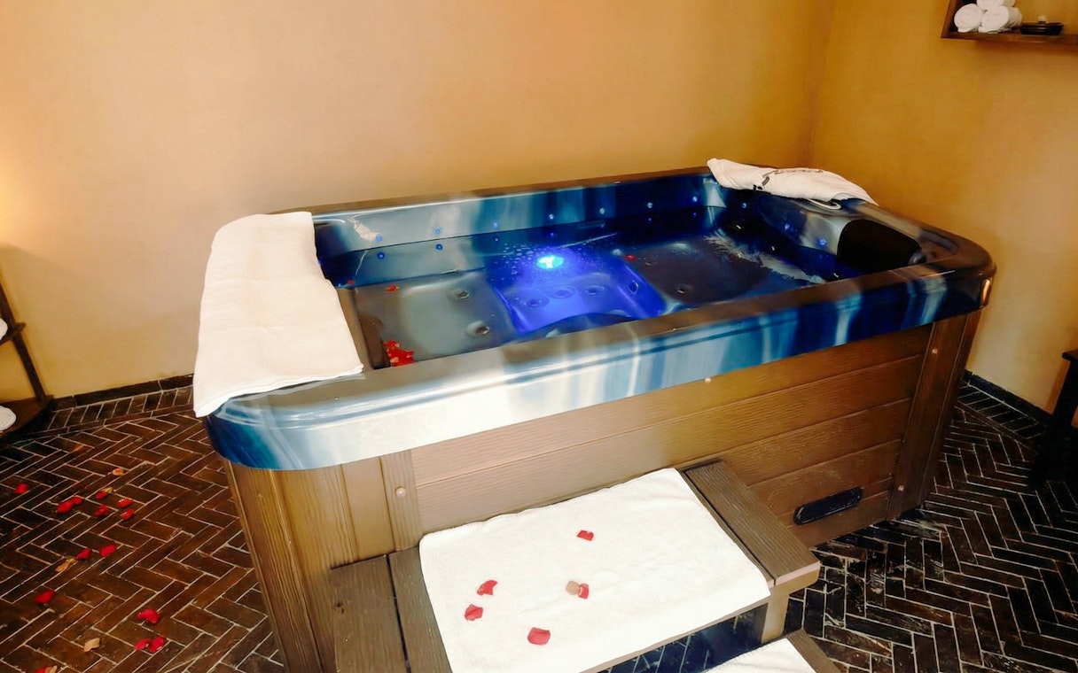 Modern spa pool with towels and rose petals at Moroccan Hammam & Spa, Marrakech.