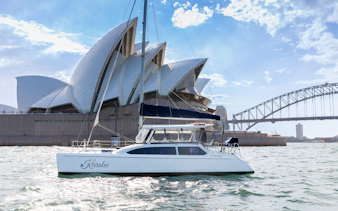 Catamaran sailing near Sydney Opera House and Harbour Bridge on Harbour Highlights Cruise.