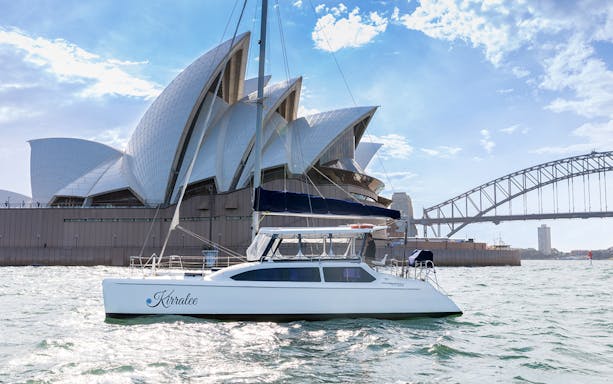 Catamaran sailing near Sydney Opera House and Harbour Bridge on Harbour Highlights Cruise.
