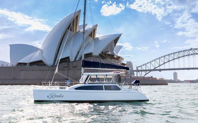 Catamaran sailing near Sydney Opera House and Harbour Bridge on Harbour Highlights Cruise.