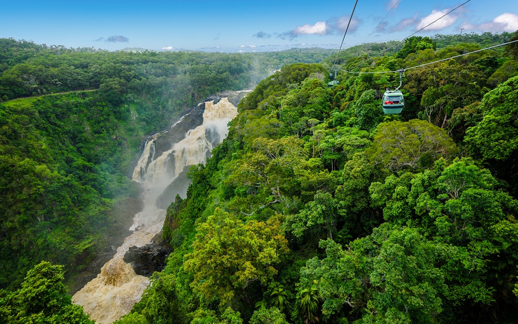Kuranda Skyrail gliding over rainforest and waterfall in Cairns, Australia.